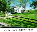 Rustic horse or corral fencing around traditional barn style farmhouse on large acre lot farmland, peaceful agriculture town at agro-town agglomeration rural environment Mansfield Missouri. USA