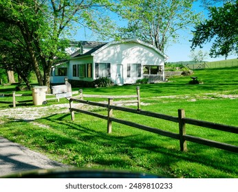 Rustic horse or corral fencing around traditional barn style farmhouse on large acre lot farmland, peaceful agriculture town at agro-town agglomeration rural environment Mansfield Missouri. USA - Powered by Shutterstock