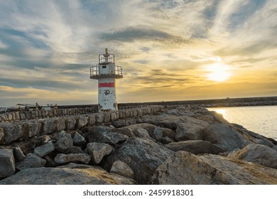 Rustic Lighthouse on the Jetty at Sunset, sunset glow on weathered lighthouse on a rock pier.