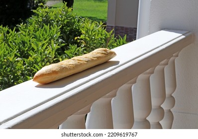 A rustic loaf of bread on a balcony - Shutterstock ID 2209619767