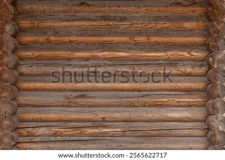 A rustic log cabin wall with horizontally aligned wooden logs.