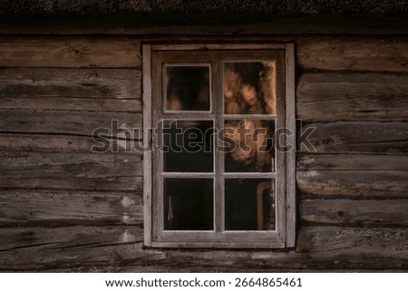 Rustic Log cabin and window with a reflection of sunrise. Old wooden log house window background.