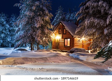 Rustic Log House, Snow-covered Pine Trees, Big Snowdrifts, Fabulous Winter Night. Rural Beautiful Winter Landscape. Non-urban Scene. New Year, Christmas. Copy Space.