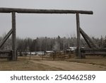 A rustic looking entrance gate built and supported out of heavy logs.