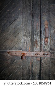 Rustic Metal Bar And Lock On Old Picturesque Timber Doors That Have Been Chipped And Carved With Initials Over The Years