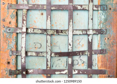 Rustic Metal Bar On Antique Wooden Door With Peeled Paint. 