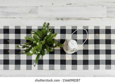 Rustic Modern Farmhouse Style Background With White Lantern And Pine Tree On Black And White Checked Runner