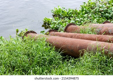 Rustic old dredging pipes stored near the riverbank close up shot
