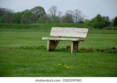 Rustic old live edge solid timber bench on green field