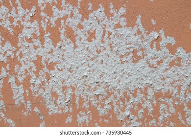 Rustic orange wall with white paint on it