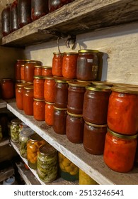 Rustic pantry shelves lined with assorted homemade pickles, preserves, and jars of vibrant fruits and vegetables