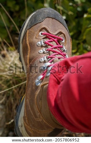 A rustic photo of hiking boots with a blurry nature background.