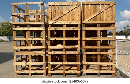 A rustic pile of weathered wooden crates, stacked outdoors and showing signs of age. Perfect for themes of recycling, vintage decor, or industrial aesthetics, highlighting natural textures and history - Powered by Shutterstock