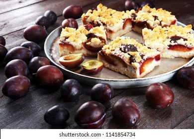 Rustic Plum Cake On Wooden Background With Plums Around