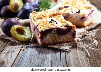 Rustic Plum Cake On Wooden Background With Plums Around