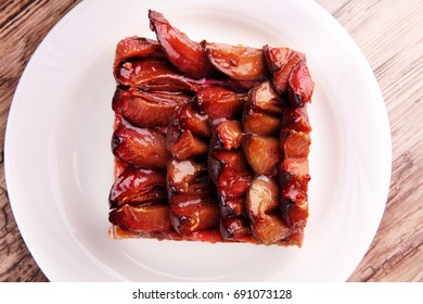 Rustic Plum Cake On Wooden Background With Plums Around