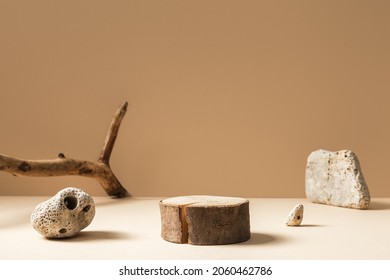 Rustikales Podium mit Zylinderform, Steinen und getrockneten Ästen auf beigem Hintergrund. Produkt, Kosmetik, Parfum, Schmuck-Mock-up.