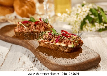 Rustic Pulled Beef Bruschetta on Wooden Board in Sunlit Setting.