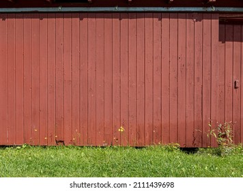 Rustic Red Barn In The Sun With Wild Flowers