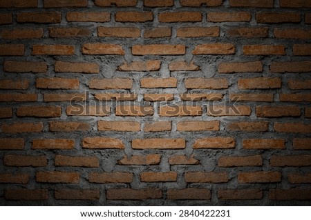 Rustic red brick wall texture background with center spotlight, dramatic dark vignette clay brickwork.