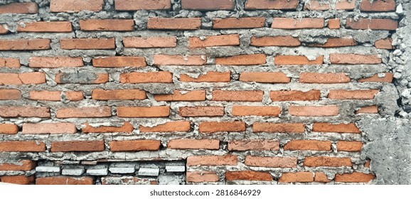 Rustic red brick wall with a weathered appearance.