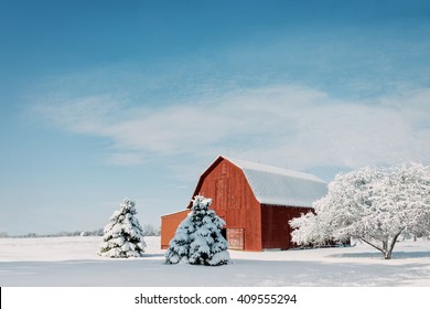 A Rustic Red Ohio Barn Covered In Fresh Snow With A Bright Blue Sky Background.