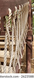 Rustic ropework banister and railing on outdoor stairs.