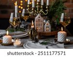 Rustic Scandinavian style zero waste eco-friendly dinner table decor for Christmas or new year family celebration. Wooden table, natural elements like pine cones, fir tree branches, candles