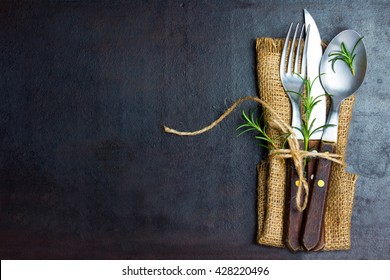 Rustic set of cutlery knife, spoon, fork. Black background. Top view - Powered by Shutterstock