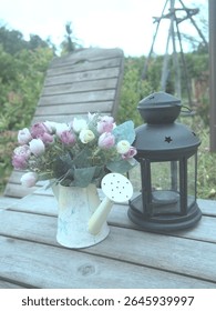 A rustic setting featuring a softly lit lantern next to a delicate flower arrangement, evoking tranquility and peaceful outdoor decor.