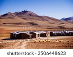 Rustic settlement in Bolivia’s remote highlands, nestled against a backdrop of barren mountains. Perfect for illustrating rural life, isolation, and sustainable living in harsh environments.