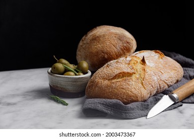 Rustic sourdough ciabatta bread with olives on a marble table. Freshly baked artisan ciabatta bread  - Powered by Shutterstock