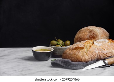 Rustic sourdough ciabatta bread with olives on a marble table. Freshly baked artisan ciabatta bread  - Powered by Shutterstock