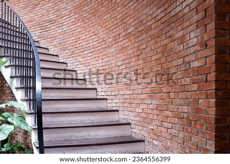 rustic staircase with red brick wall