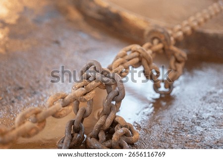 Rustic steel chain with hook is using to fastening and restraining on the heavy object, secure for the transportation. Transporation industrial equipment object, close-up with selective focus.