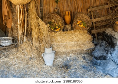 rustic stil life in old traditional vintage style with basket of fruit , hay and vintage dishes and vases , paesant background