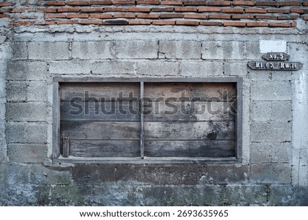 Rustic stone brick wall texture with a boarded-up wooden window, showing decay and industrial architectural detail
