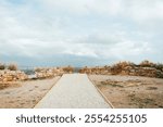 Rustic Stone Pathway Between Ancient Ruins Under a Cloudy Sky