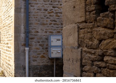 Rustic stone wall and mailboxes in quaint village setting for architectural design.