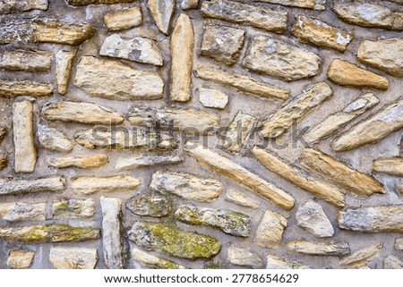 Rustic stone wall with weathered texture and irregular shapes.