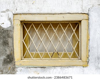Rustic style aged yellow window at rural home wall.