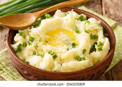 Rustikaler Stil Kartoffelpüree mit grünen Zwiebeln und Butter, Nahaufnahme in einer Schüssel auf dem Tisch. horizontal