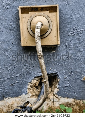 Rustic style outdoor electrical outlet on weathered blue wall, ideal for “grubby texture” and “grubby urban” themes.