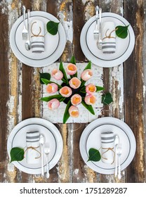 A Rustic Table Of Repurposed Wood And Vintage Elements Gives A Warm And Cozy Vibe With Tulips As A Cheerful Centerpiece. Sitting Atop An Old Tin Ceiling Tile. A Touch Of Nature Completes The Design.