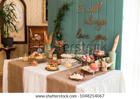 a rustic table, sealed with cheese, nuts, fruits and sweets. A wooden background