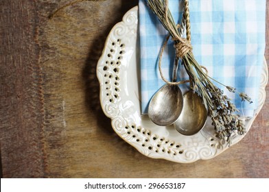 Rustic Table Setting with napkin, silverware and dry lavendre lowers on old wooden table