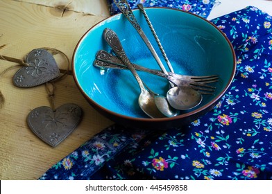 Rustic table setting with vintage silverware ad plates on old styled napkins