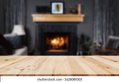 Rustic table top with blurred fireplace in luxurious home interior. Table background with empty space for products and decorations. - Powered by Shutterstock