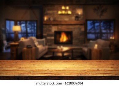 Rustic Table Top With Blurred Fireplace In Luxurious Home Interior. Table Background With Empty Space For Products And Decorations.