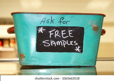 Rustic tin basket sitting on counter that says Ask for free samples